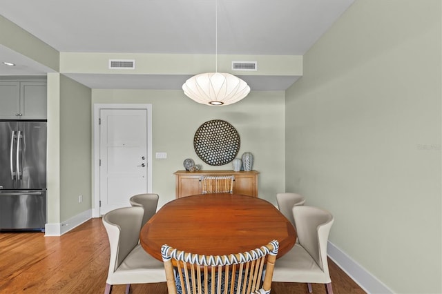 dining room with visible vents, baseboards, and wood finished floors