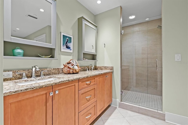 full bath with tile patterned floors, double vanity, a stall shower, and a sink