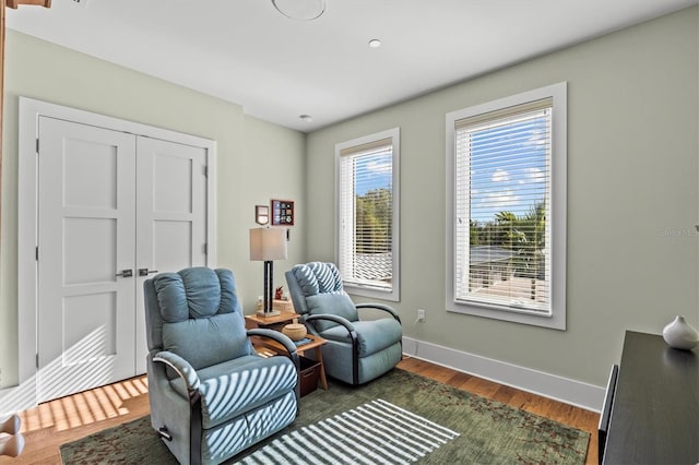 living area with baseboards and dark wood finished floors