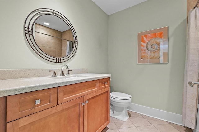 bathroom featuring tile patterned flooring, toilet, vanity, and baseboards