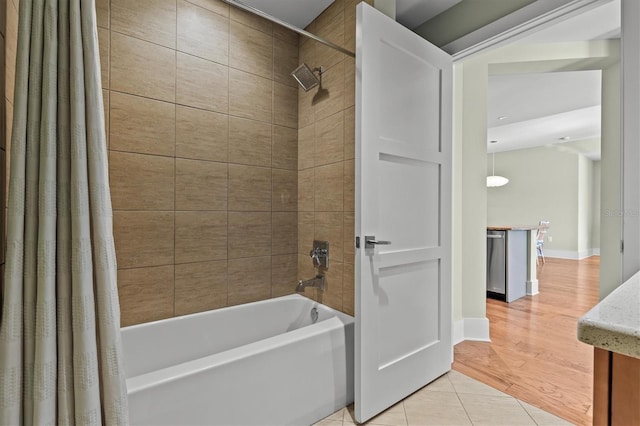 full bath with tile patterned flooring, baseboards, and shower / bath combo