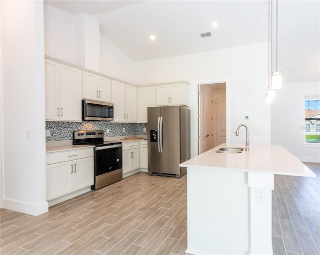 kitchen with wood finish floors, visible vents, a sink, appliances with stainless steel finishes, and light countertops