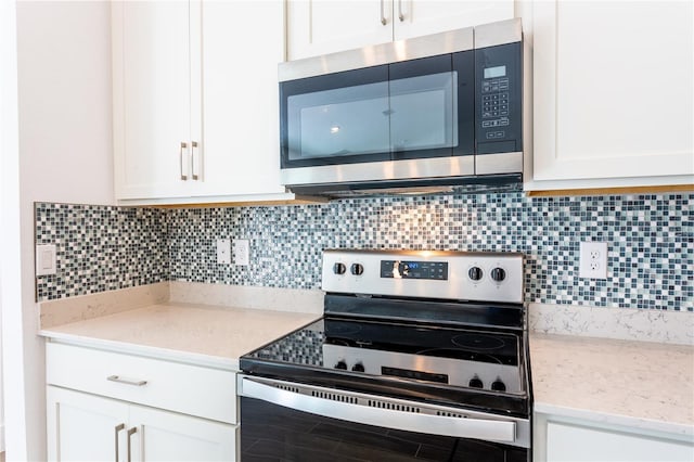 kitchen featuring backsplash, appliances with stainless steel finishes, and white cabinetry