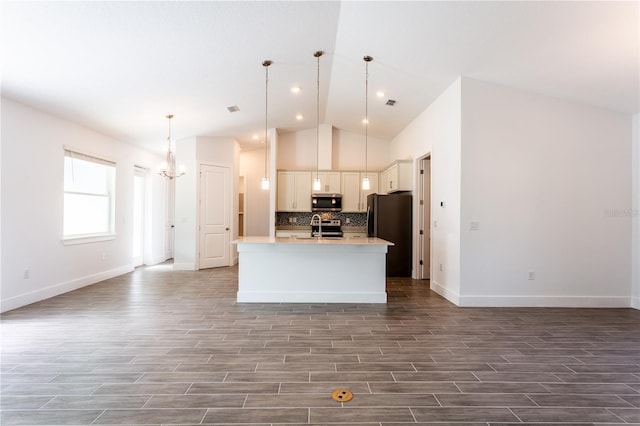 kitchen featuring a center island with sink, tasteful backsplash, wood finished floors, open floor plan, and appliances with stainless steel finishes