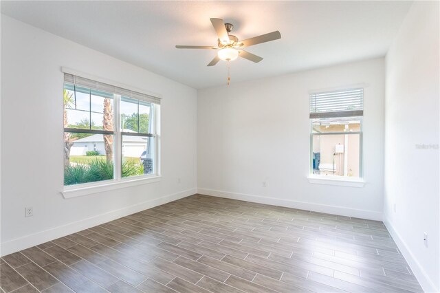 empty room with baseboards, a ceiling fan, and wood finished floors