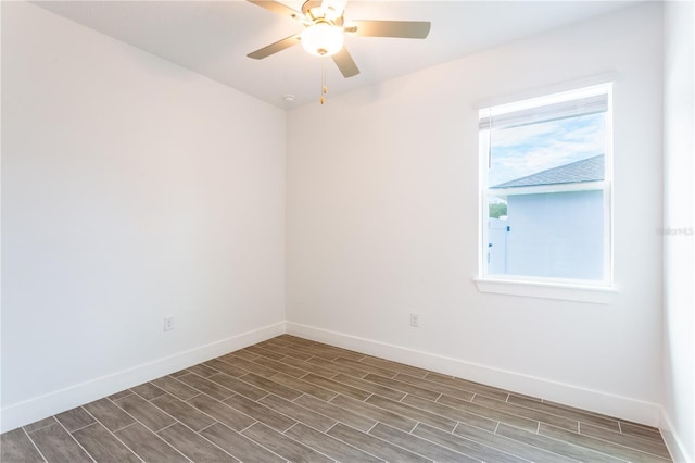 unfurnished room featuring baseboards, ceiling fan, and wood tiled floor