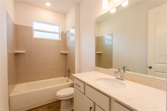 bathroom featuring vanity, toilet, wood finished floors, and bathing tub / shower combination