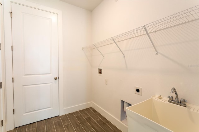 laundry area featuring hookup for a washing machine, baseboards, wood tiled floor, laundry area, and a sink