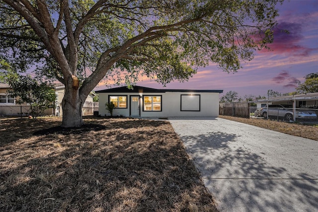 view of front facade with concrete driveway and fence