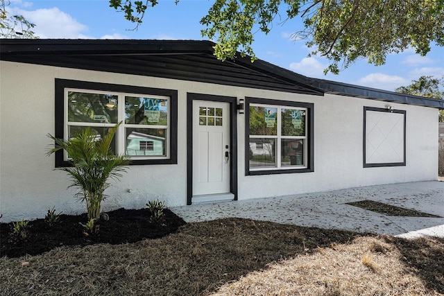 view of exterior entry featuring stucco siding