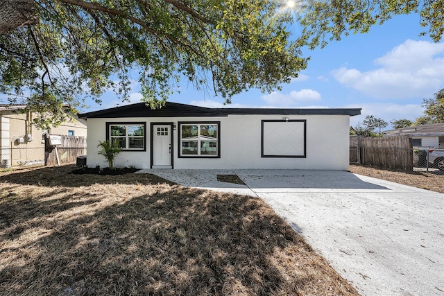 ranch-style home with stucco siding and fence