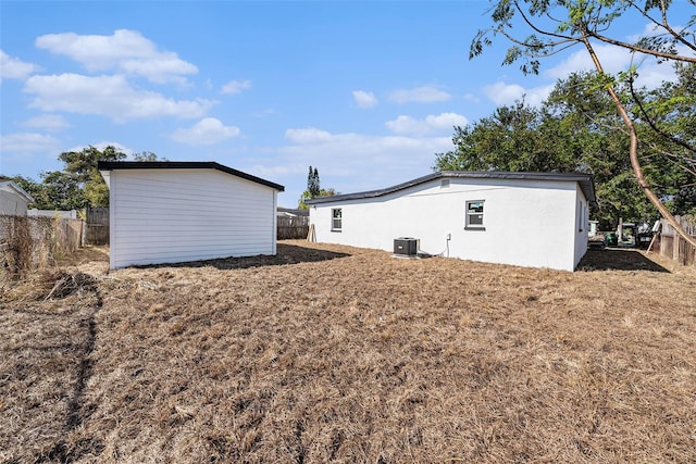 view of property exterior with central AC unit and fence