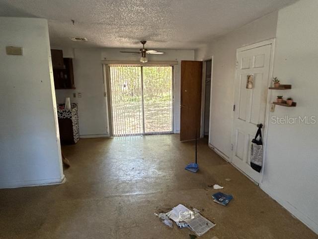 interior space featuring a textured ceiling, concrete flooring, and ceiling fan