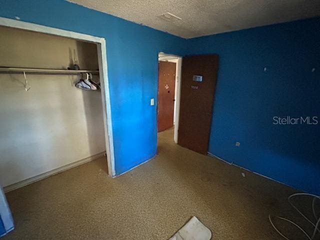 unfurnished bedroom with a closet and a textured ceiling