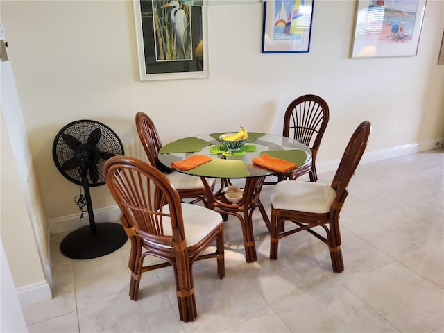 dining space featuring light tile patterned floors and baseboards