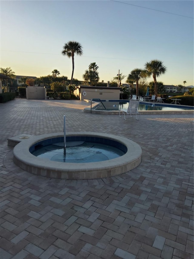 community pool with a community hot tub and a patio area