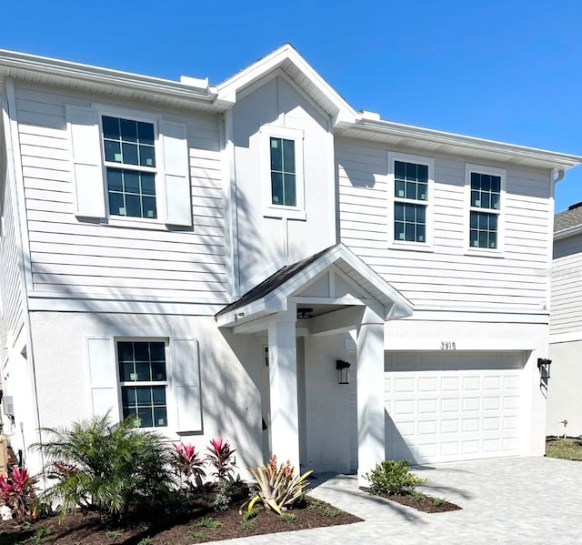 view of front of home featuring an attached garage, driveway, and stucco siding