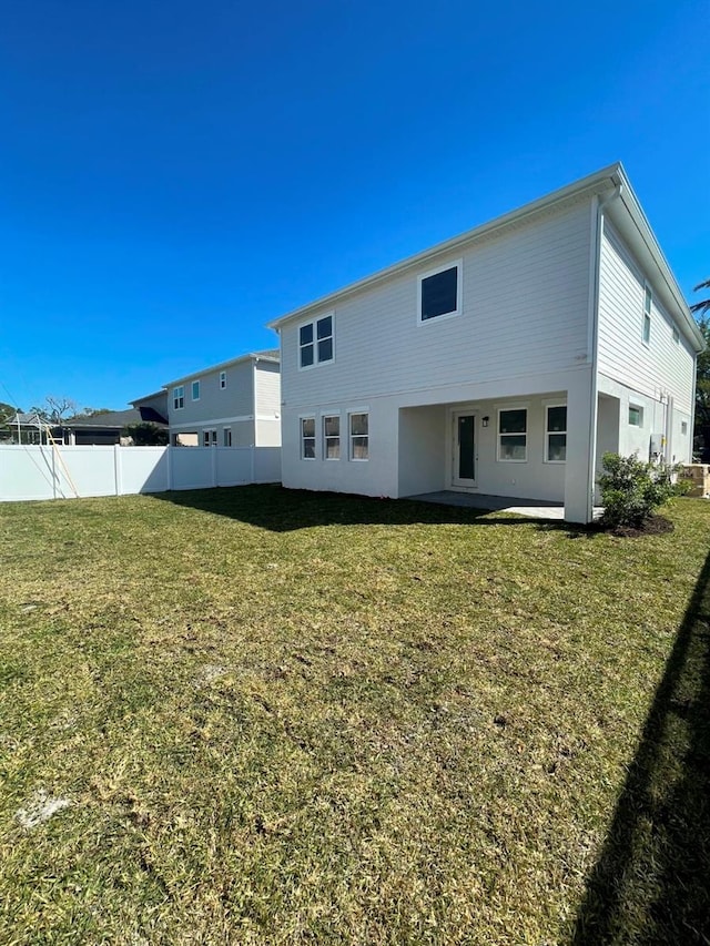 rear view of property with a patio area, a yard, and fence