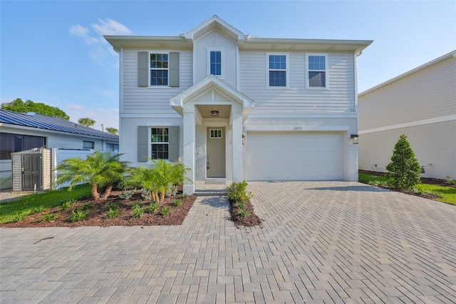traditional home with stucco siding, an attached garage, and decorative driveway