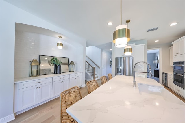 dining room featuring recessed lighting, stairway, visible vents, and light wood-style flooring