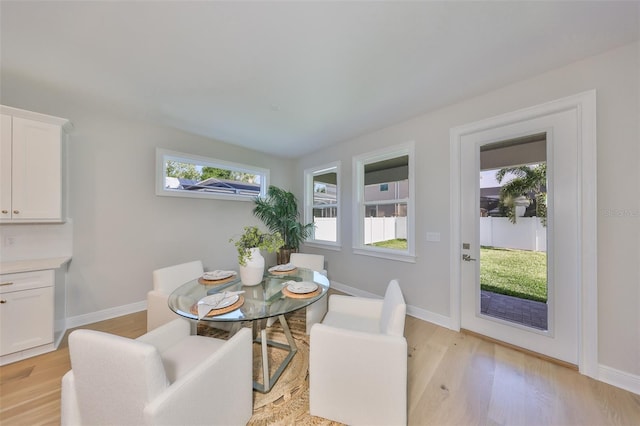 dining area with light wood finished floors and baseboards