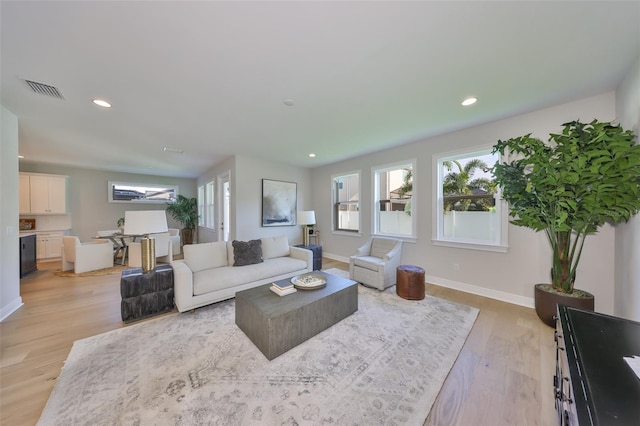 living area featuring recessed lighting, visible vents, light wood finished floors, and baseboards