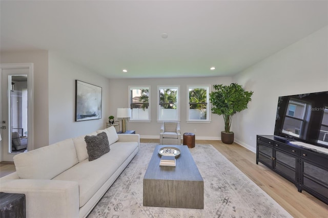 living area with light wood finished floors, baseboards, and recessed lighting