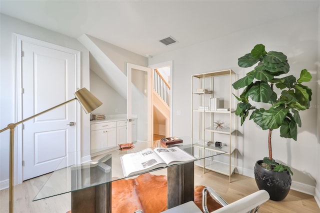 office featuring light wood-type flooring, visible vents, and baseboards