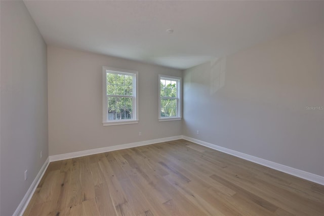 empty room with baseboards and light wood finished floors