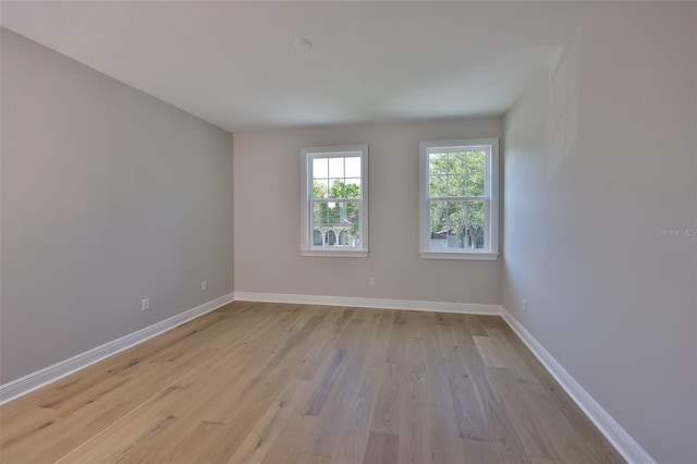 unfurnished room featuring light wood-type flooring and baseboards