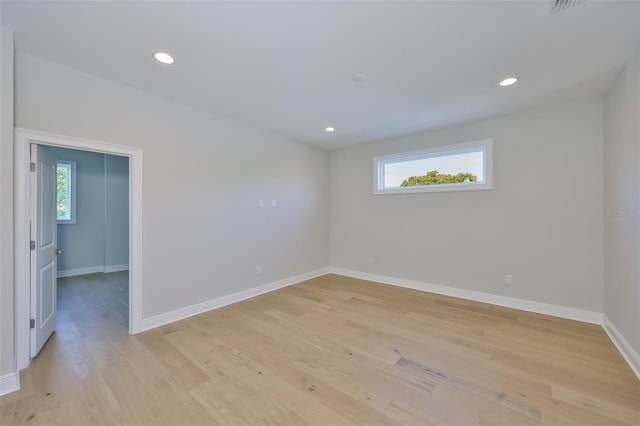 spare room with baseboards, a healthy amount of sunlight, light wood finished floors, and recessed lighting