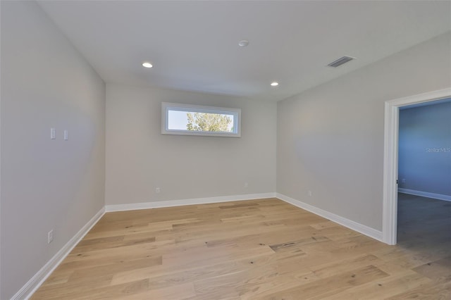 spare room with light wood-type flooring, baseboards, visible vents, and recessed lighting