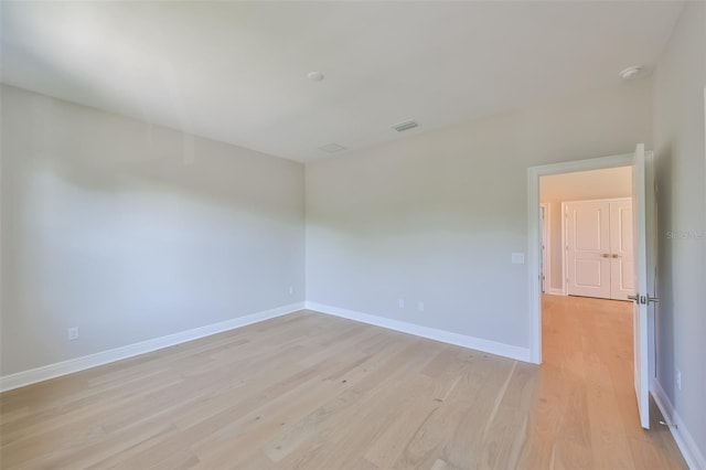 spare room with visible vents, baseboards, and light wood-style floors