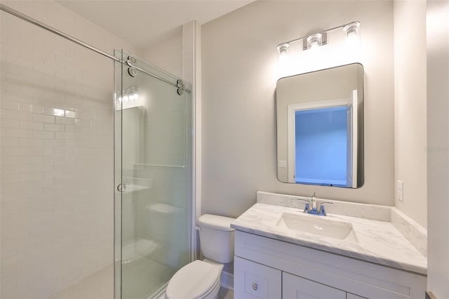 bathroom featuring vanity, a shower stall, and toilet
