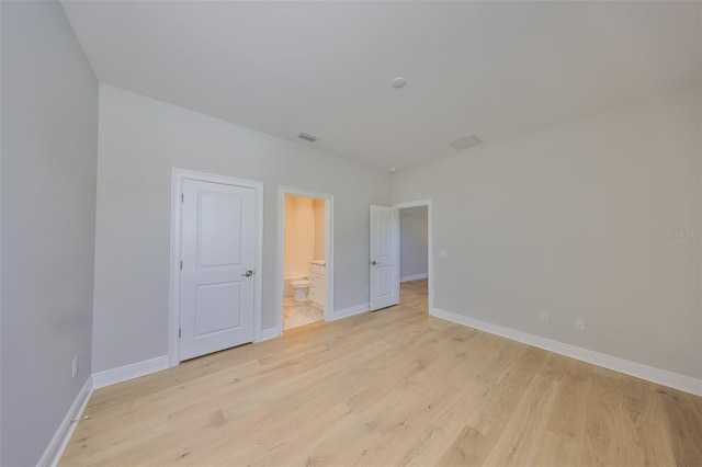 interior space featuring baseboards, visible vents, and light wood finished floors
