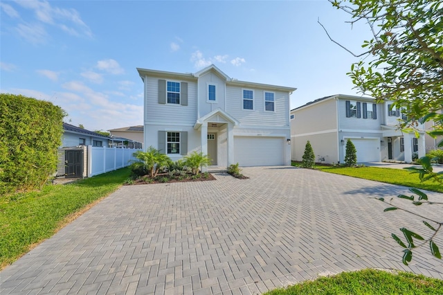 view of front of property featuring fence, decorative driveway, and a garage