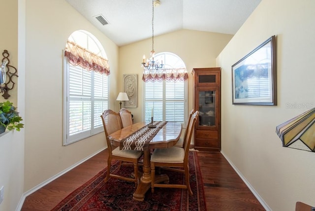 dining area featuring dark wood finished floors, lofted ceiling, a notable chandelier, and visible vents