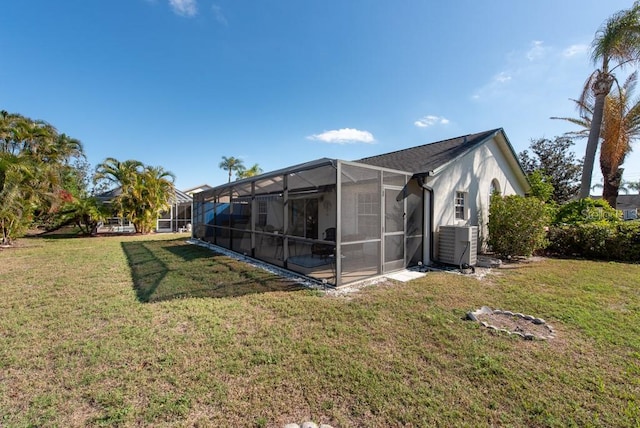 back of house with a lanai, central AC, and a yard