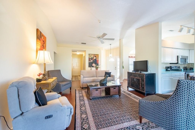 living room with visible vents, dark wood-style floors, ceiling fan, and vaulted ceiling