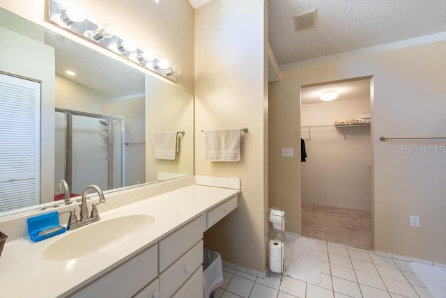 bathroom with vanity, visible vents, a stall shower, tile patterned flooring, and a spacious closet