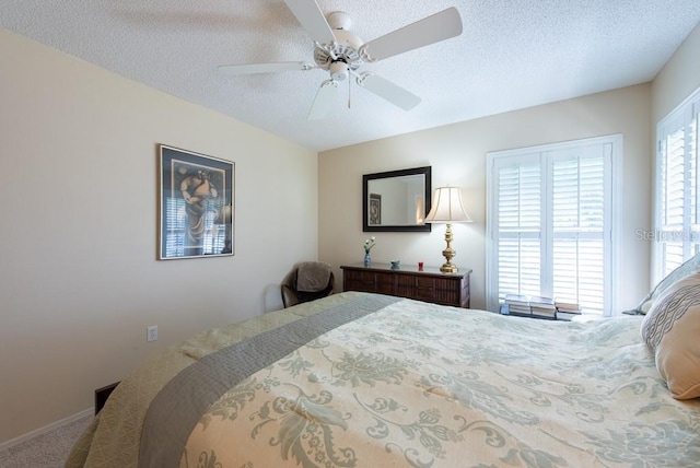 bedroom with a ceiling fan, carpet floors, and a textured ceiling