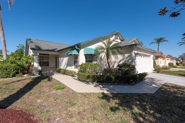 view of front of property featuring a garage, concrete driveway, a front yard, and stucco siding