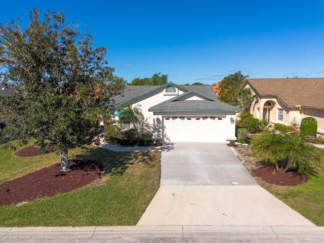 view of front of home with stucco siding, an attached garage, concrete driveway, and a front yard