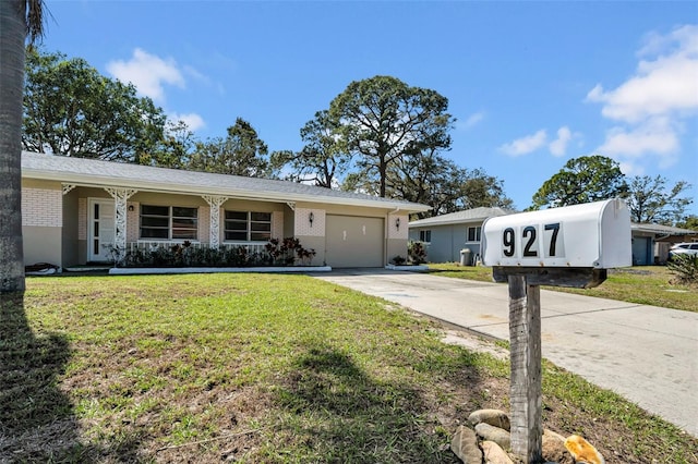 ranch-style home with brick siding, driveway, an attached garage, and a front lawn