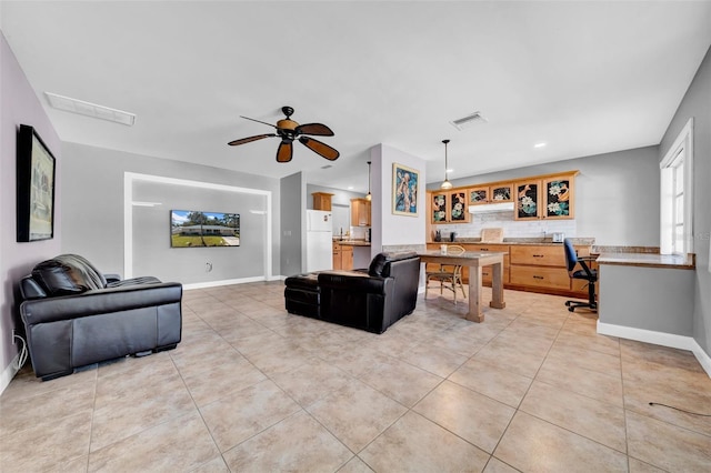 living room with light tile patterned floors, a ceiling fan, and visible vents