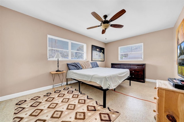 bedroom featuring a ceiling fan, baseboards, and speckled floor
