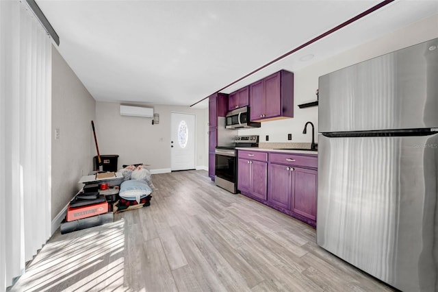 kitchen with reddish brown cabinets, stainless steel appliances, a wall unit AC, and a sink