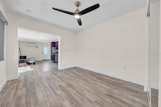 unfurnished room with baseboards, light wood-style floors, a ceiling fan, and a wall mounted AC