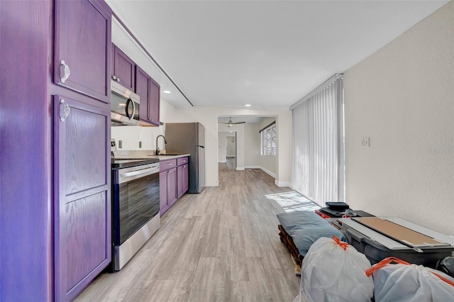 kitchen with baseboards, a sink, stainless steel appliances, light wood-type flooring, and reddish brown cabinets