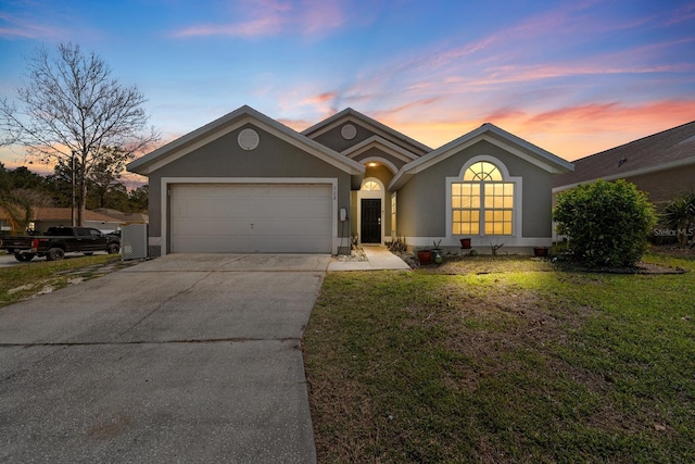 single story home with stucco siding, driveway, a front yard, and an attached garage